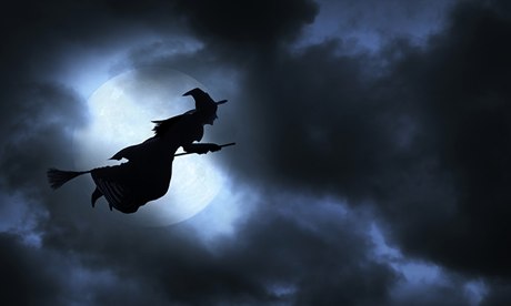 A Halloween witch flies across the face of the moon