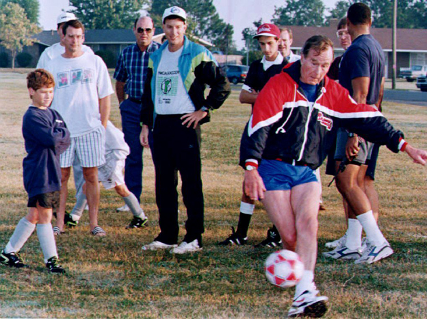 U.S. President George Bush (R) kicks a soccer ball