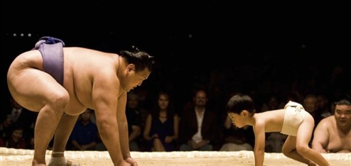 Sumo wrestler wrestling child